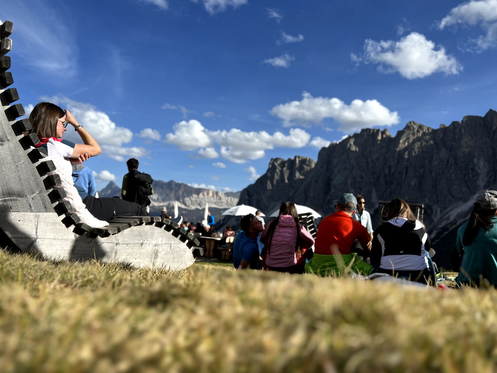 Hikers resting at mountain viewpoint with dramatic Dolomite peaks in background